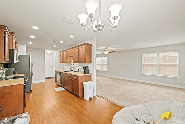 kitchen featuring ceiling fan with notable chandelier, plenty of natural light, sink, and light hardwood / wood-style flooring