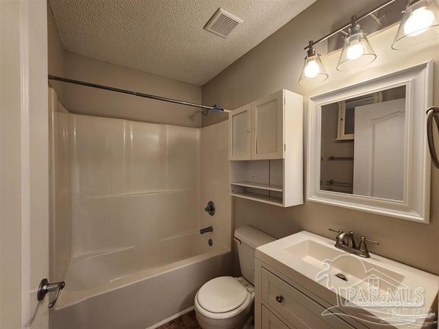 full bathroom featuring vanity, shower / bath combination, a textured ceiling, and toilet