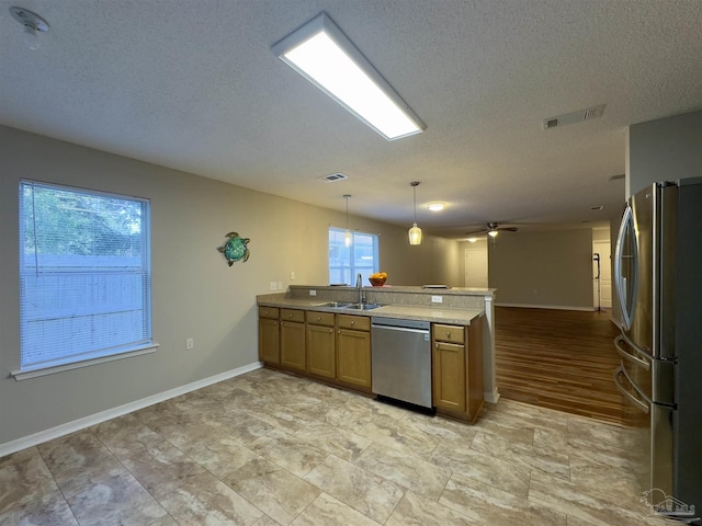 8037 Nalo Creek Loop, Pensacola, FL 32514 - kitchen with stainless steel appliances, a peninsula, open floor plan, brown cabinets, and a textured ceiling