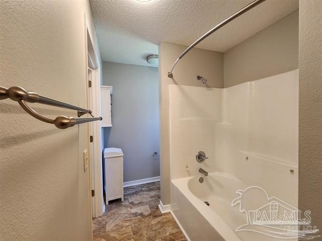 bathroom featuring shower / bath combination and a textured ceiling