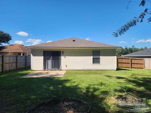 back of property with a lawn and a patio