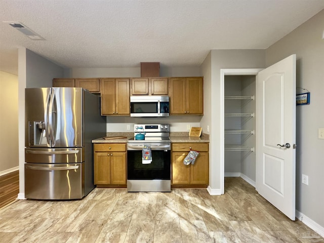 kitchen featuring stainless steel appliances and a textured ceiling