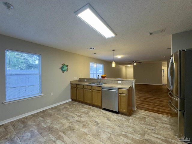 kitchen with decorative light fixtures, a healthy amount of sunlight, stainless steel appliances, and ceiling fan