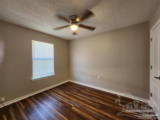 spare room with ceiling fan, wood-type flooring, and a textured ceiling