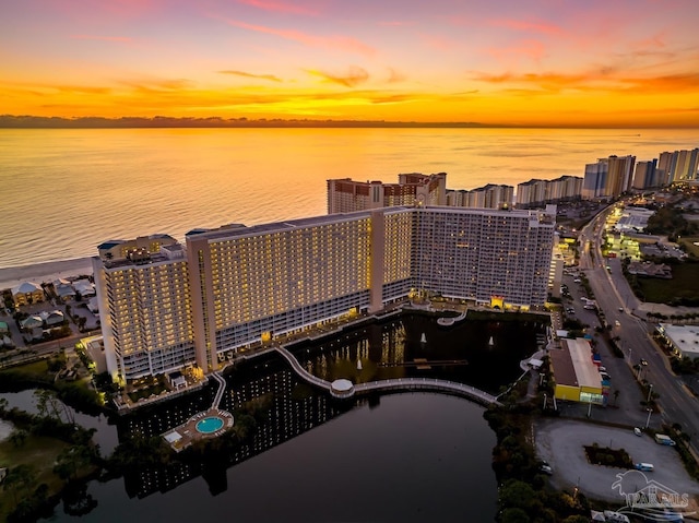 aerial view at dusk featuring a water view