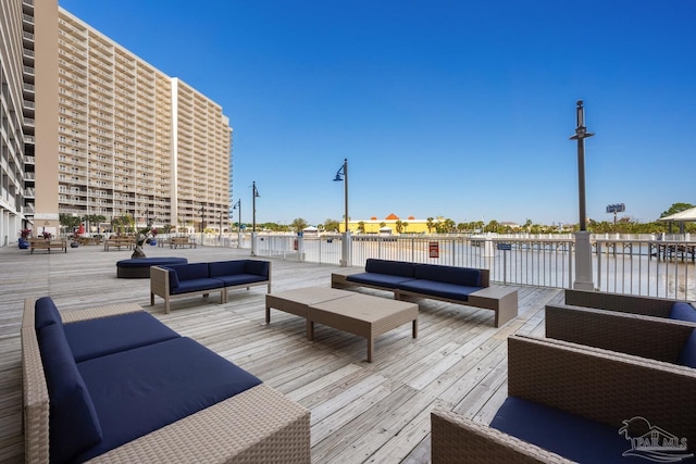 deck with an outdoor living space and a water view