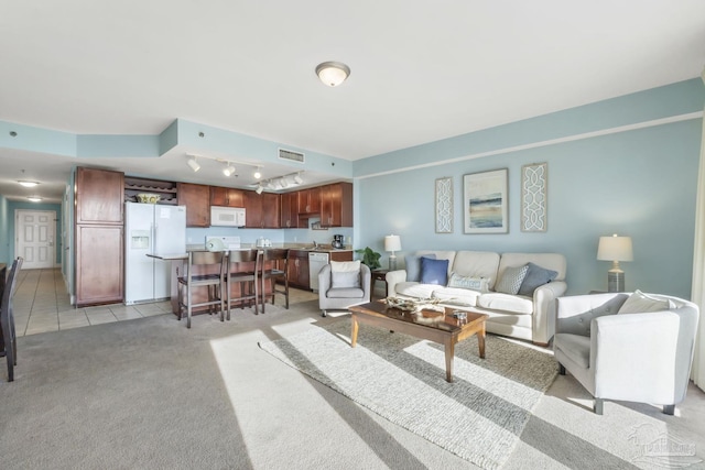 living room with track lighting and light colored carpet