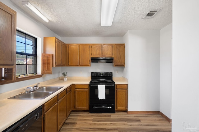 kitchen featuring light hardwood / wood-style flooring, a textured ceiling, black appliances, and sink