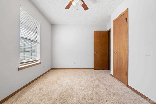 carpeted empty room with a textured ceiling and ceiling fan