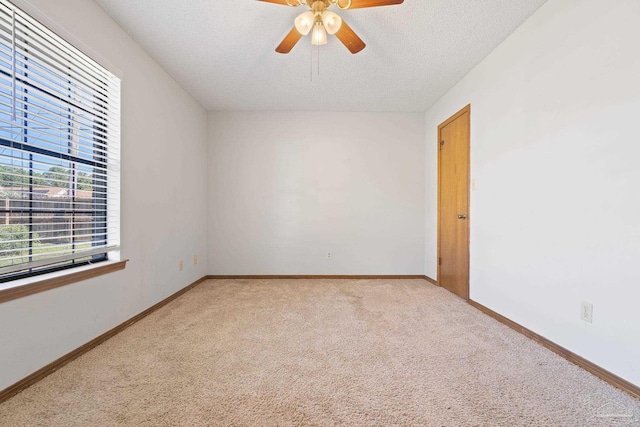 carpeted spare room featuring a textured ceiling and ceiling fan