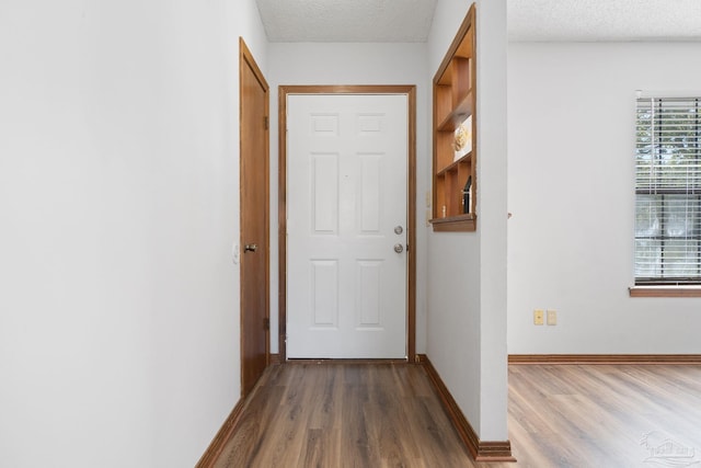 hallway featuring a textured ceiling and hardwood / wood-style floors