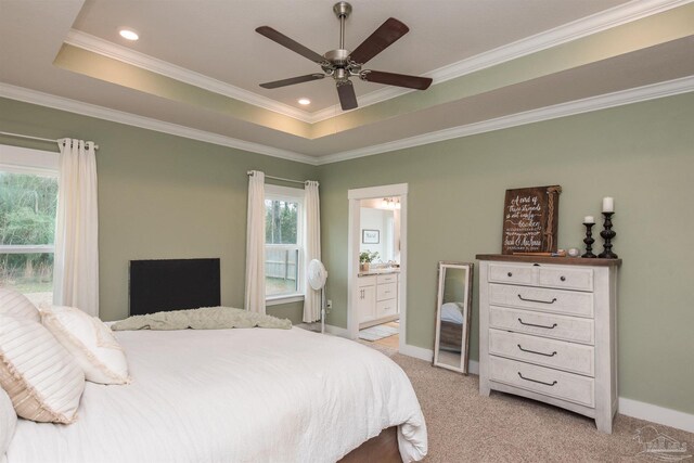 bedroom with connected bathroom, a raised ceiling, ceiling fan, and ornamental molding