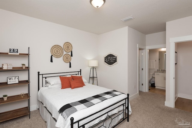 carpeted bedroom featuring ensuite bathroom