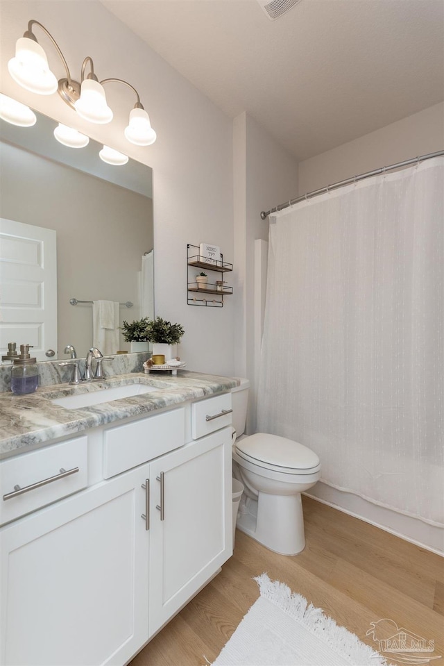 bathroom featuring toilet, vanity, and hardwood / wood-style flooring