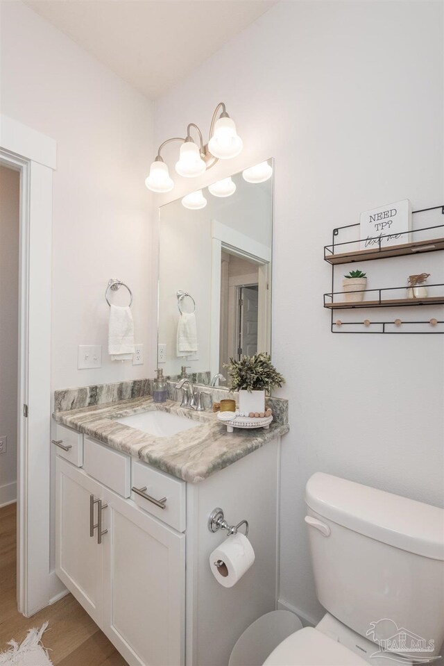 bathroom featuring vanity, hardwood / wood-style flooring, and toilet