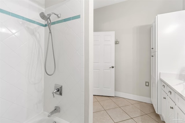 bathroom featuring tile patterned flooring, tiled shower / bath combo, and vanity