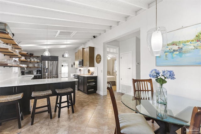 dining space with beamed ceiling and light tile patterned flooring