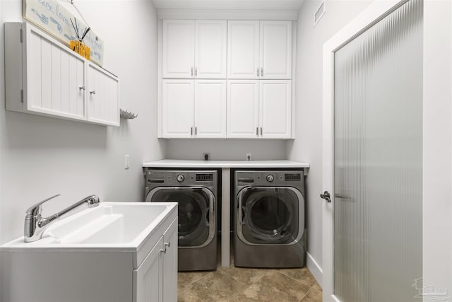 laundry room with cabinets, washing machine and dryer, and sink