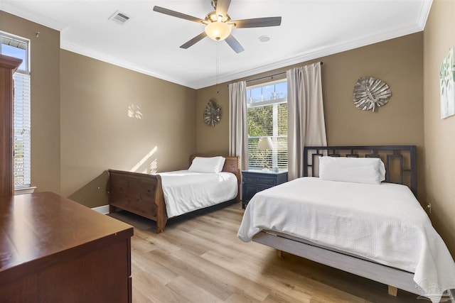 bedroom featuring ceiling fan, ornamental molding, and light wood-type flooring