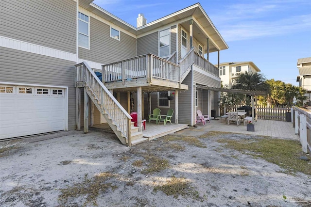 rear view of property featuring a patio area and a wooden deck