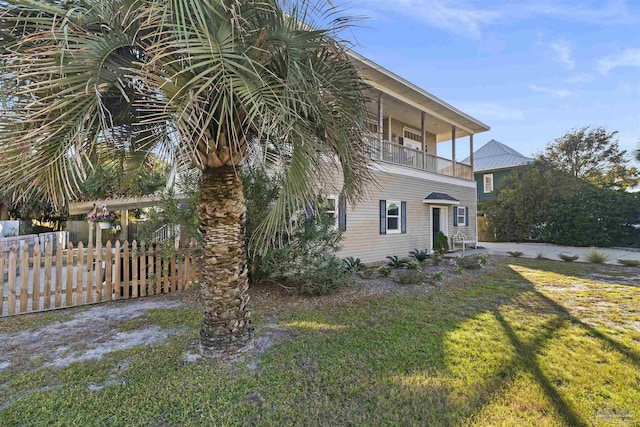 view of property exterior with a balcony and a yard