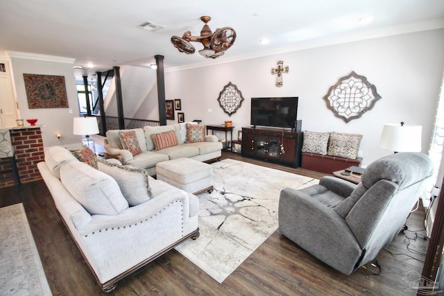 living room featuring dark wood-type flooring, a chandelier, and ornamental molding