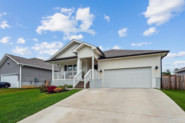 view of front of house with a front lawn, covered porch, and a garage