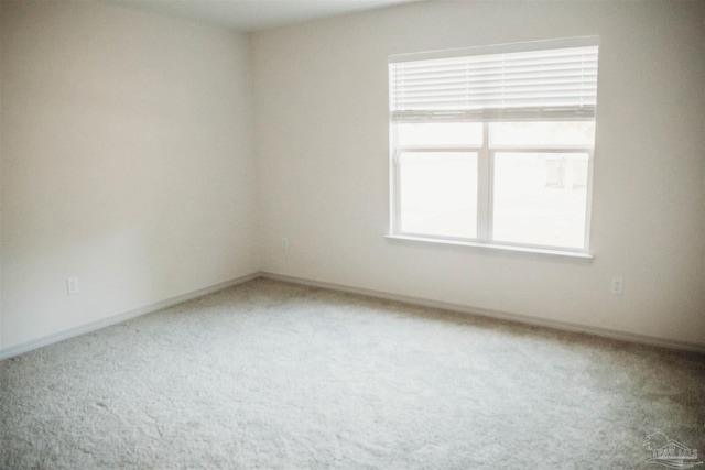 carpeted spare room featuring a healthy amount of sunlight