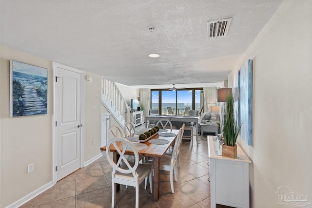 tiled dining space with a textured ceiling