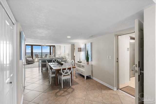 dining area featuring light tile patterned floors and a textured ceiling