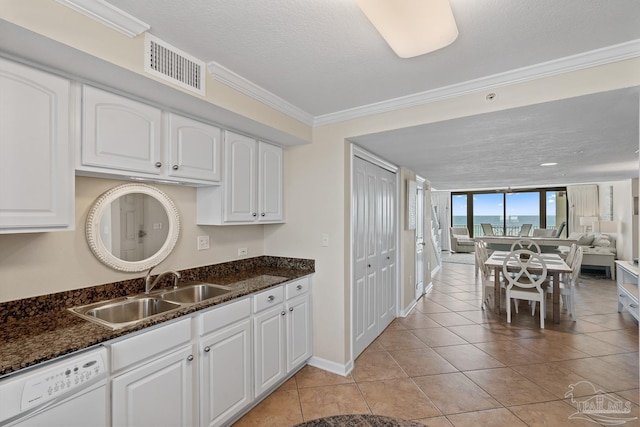 kitchen featuring white cabinetry, dark stone counters, white dishwasher, and sink