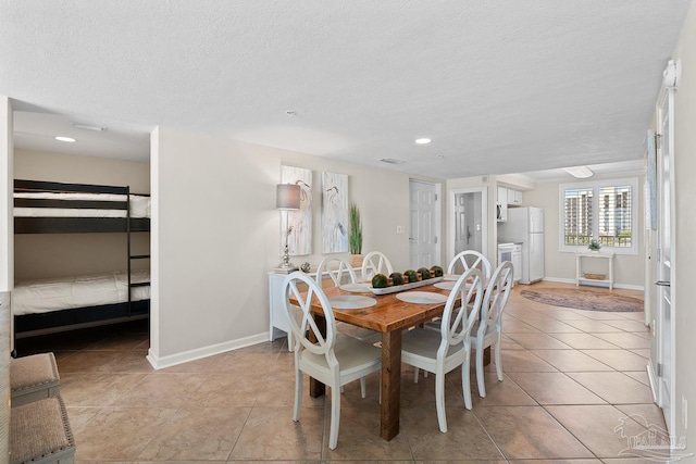 tiled dining area with a textured ceiling