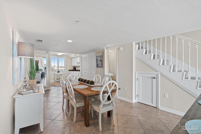 tiled dining area with a textured ceiling