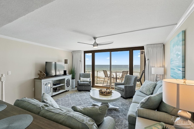 living room featuring ceiling fan, ornamental molding, and a textured ceiling