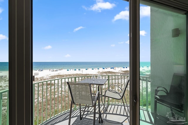 balcony with a water view and a view of the beach