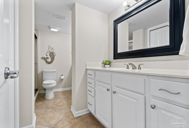 bathroom featuring vanity, toilet, tile patterned flooring, and a textured ceiling