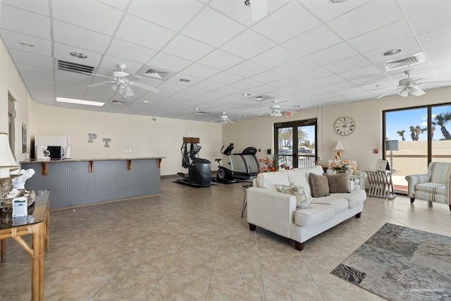 tiled living room featuring a drop ceiling, french doors, and ceiling fan