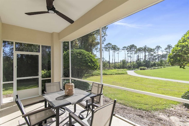 sunroom / solarium featuring a ceiling fan