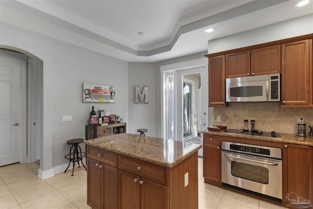 kitchen featuring tasteful backsplash, arched walkways, ornamental molding, stainless steel appliances, and light tile patterned flooring