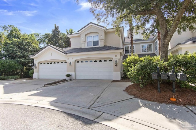 traditional-style home with concrete driveway, a tile roof, and stucco siding