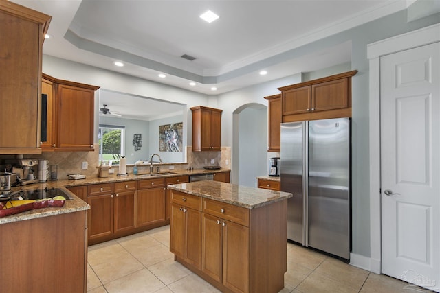 kitchen with visible vents, a center island, a tray ceiling, stainless steel appliances, and a sink