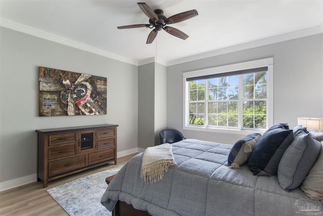 bedroom featuring baseboards, light wood-style flooring, and crown molding