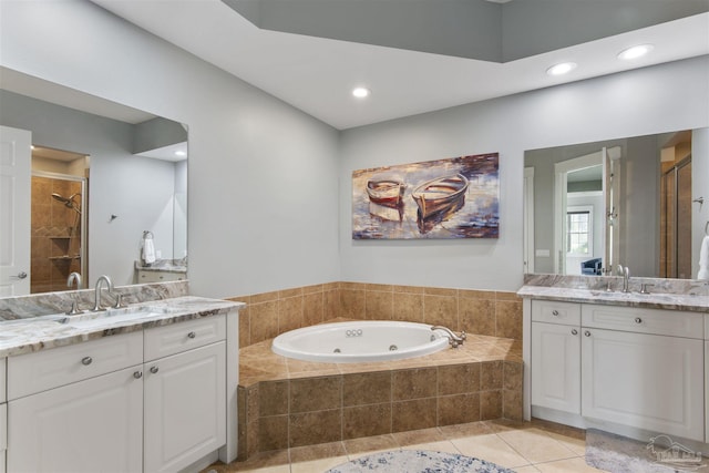 bathroom featuring a sink, a jetted tub, a shower stall, and tile patterned floors