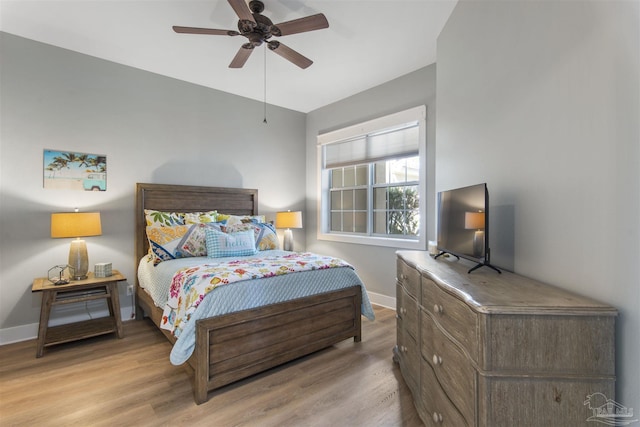 bedroom with ceiling fan, baseboards, and wood finished floors