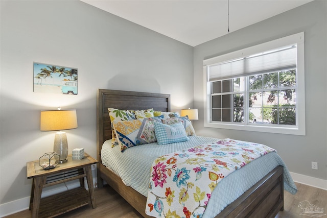 bedroom with baseboards and wood finished floors