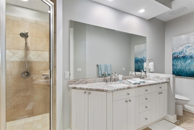 full bath with toilet, a shower stall, double vanity, and a sink