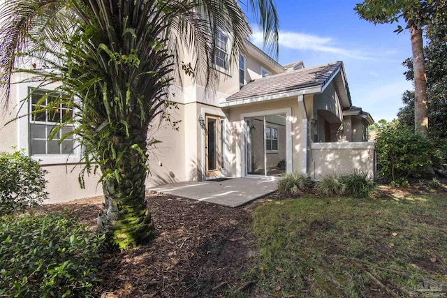 back of property with a patio and stucco siding