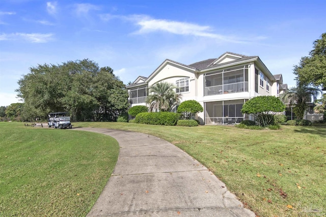 view of front facade with a sunroom and a front lawn