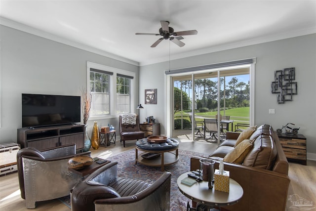 living room with a ceiling fan, crown molding, baseboards, and wood finished floors