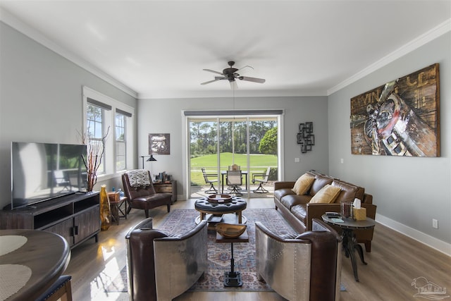 living room featuring baseboards, ceiling fan, wood finished floors, and crown molding